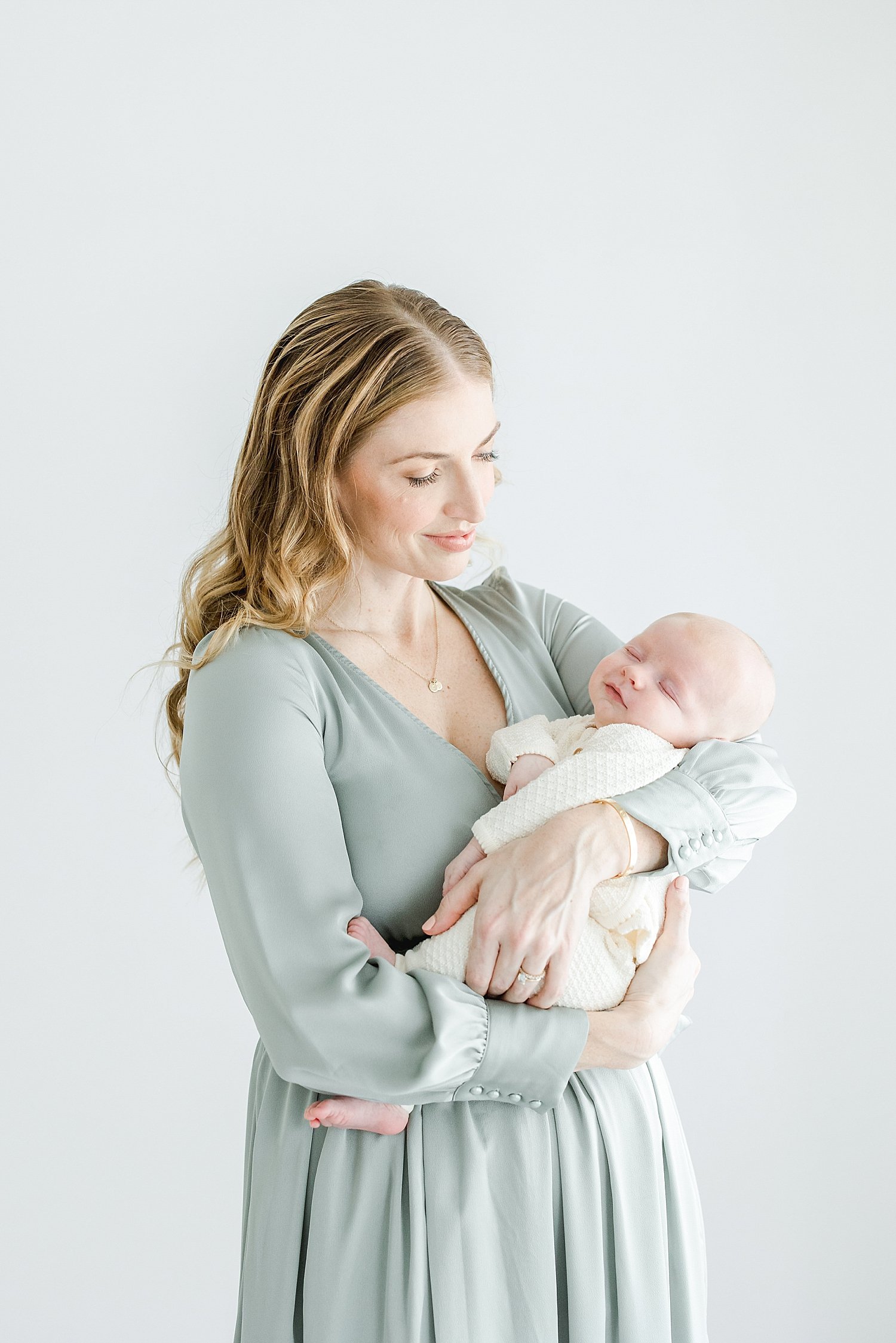 Mom holding her newborn son for photos with Kristin Wood Photography.