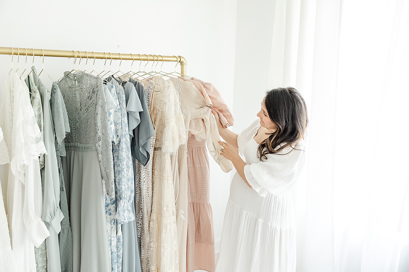What To Wear for Your Maternity Session | Mom picking out a dress from client wardrobe | Kristin Wood Photography