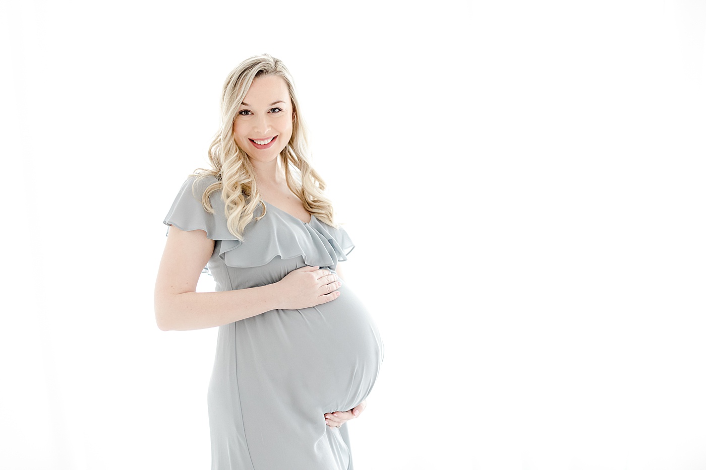 5 Reasons Why You Should Take Maternity Photos | Mom holding pregnant belly wearing a blue dress | Kristin Wood Photography