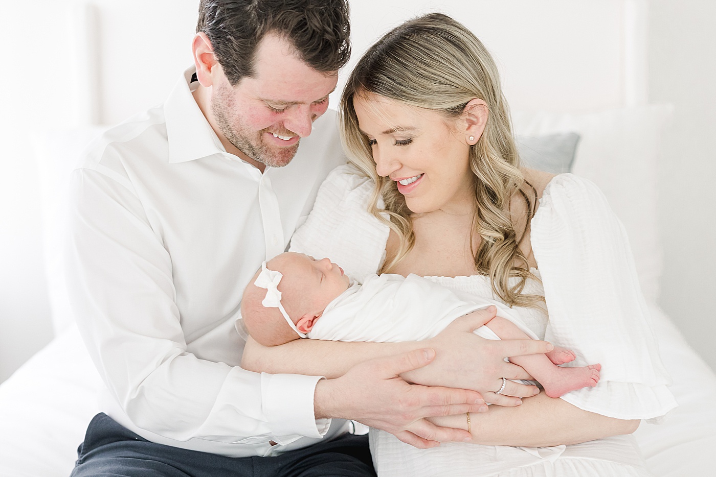 First-time parents hold baby girl for newborn photos with Kristin Wood Photography.