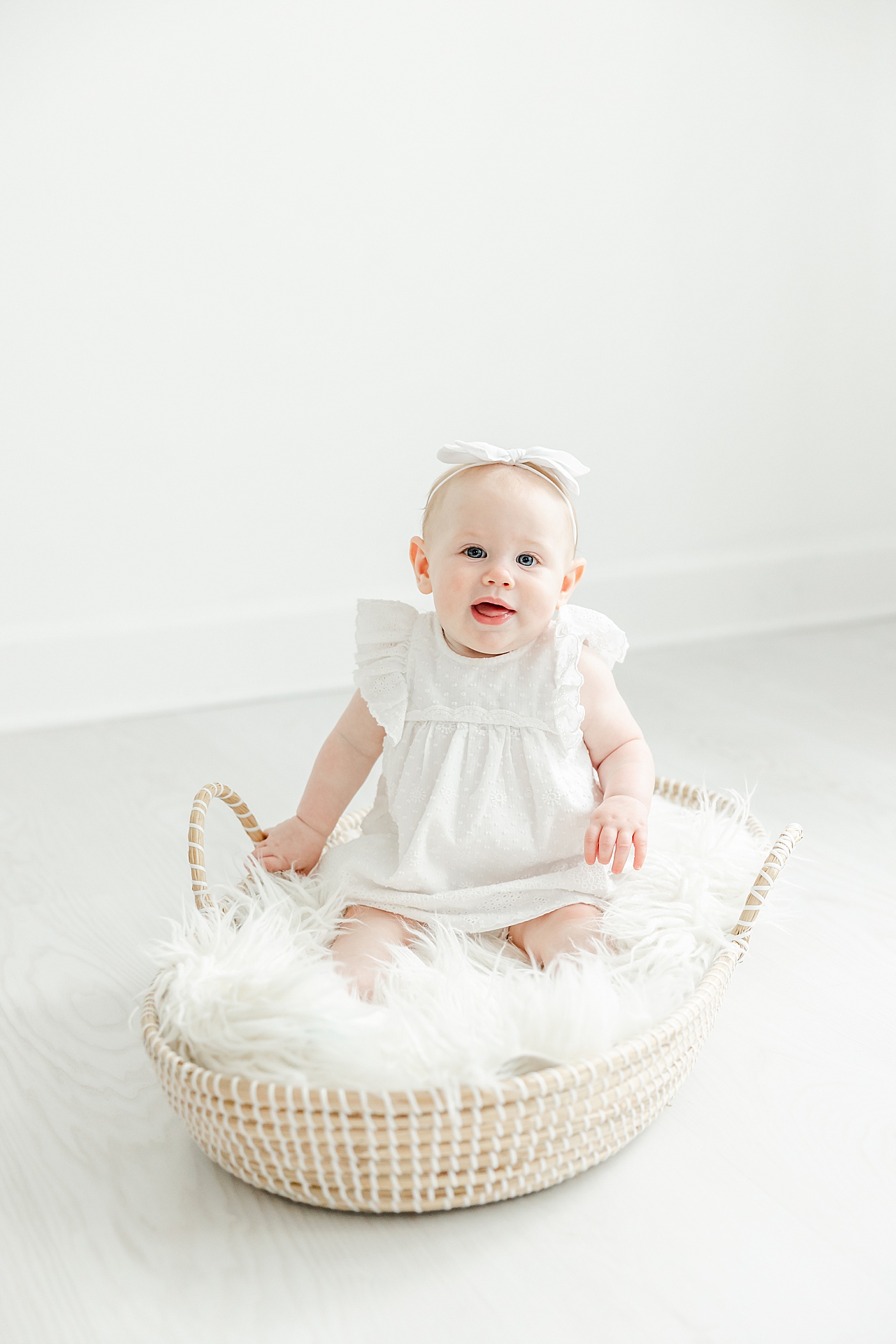Baby girl sitting on Moses basket | Kristin Wood Photography