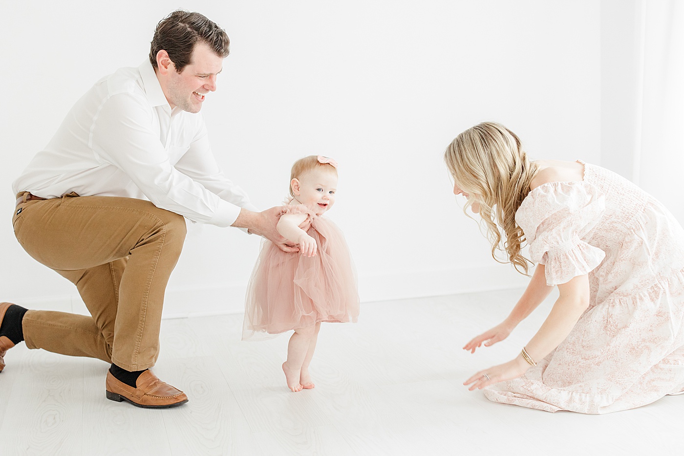 One year old walking with mom and dad | Kristin Wood Photography