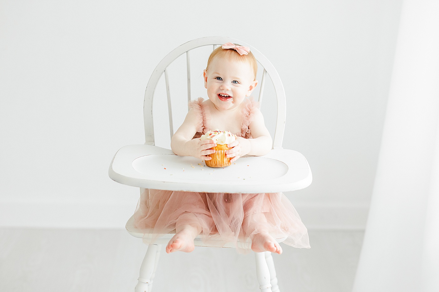 One year old with cupcake at first birthday photoshoot with Kristin Wood Photography.