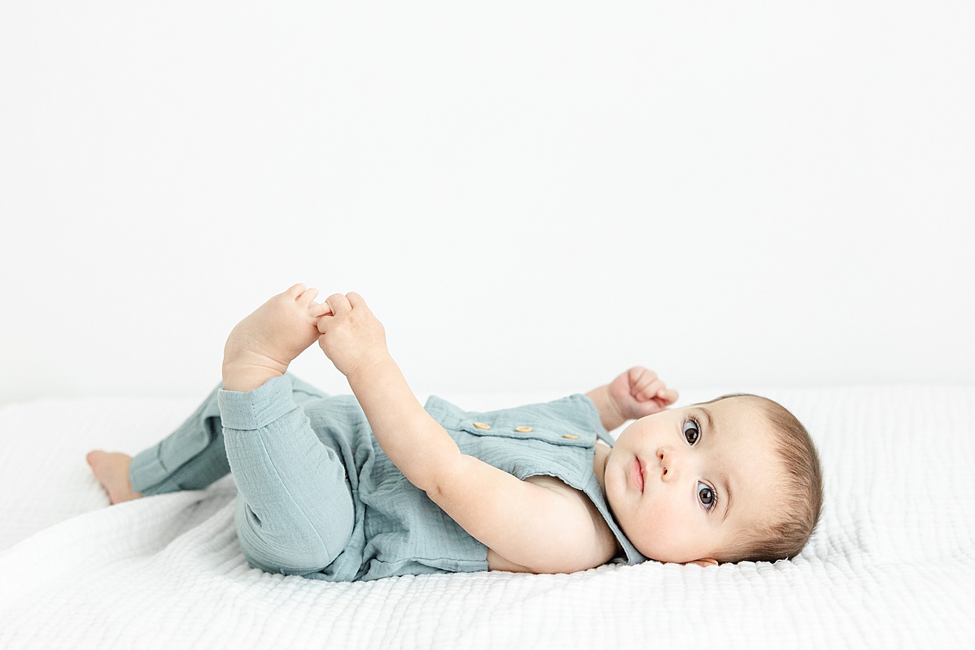 7 month old grabbing his toes during milestone session with Kristin Wood Photography.