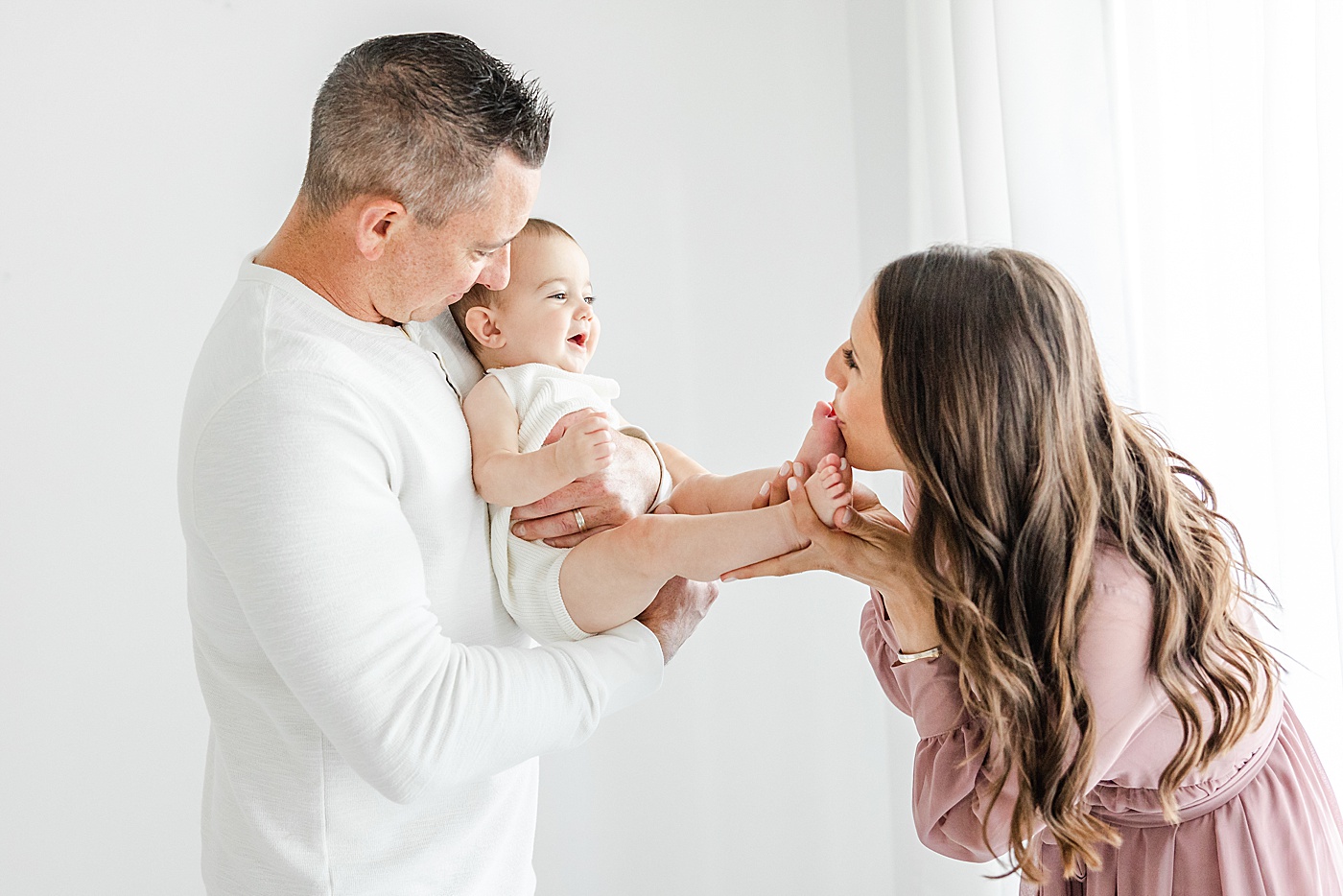 Dad holding son while Mom kisses his toes | Kristin Wood Photography