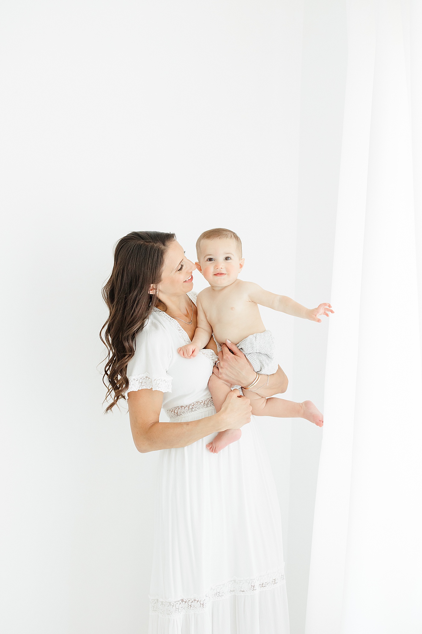 Mom holding one year old son during his first birthday photoshoot with Kristin Wood Photography.