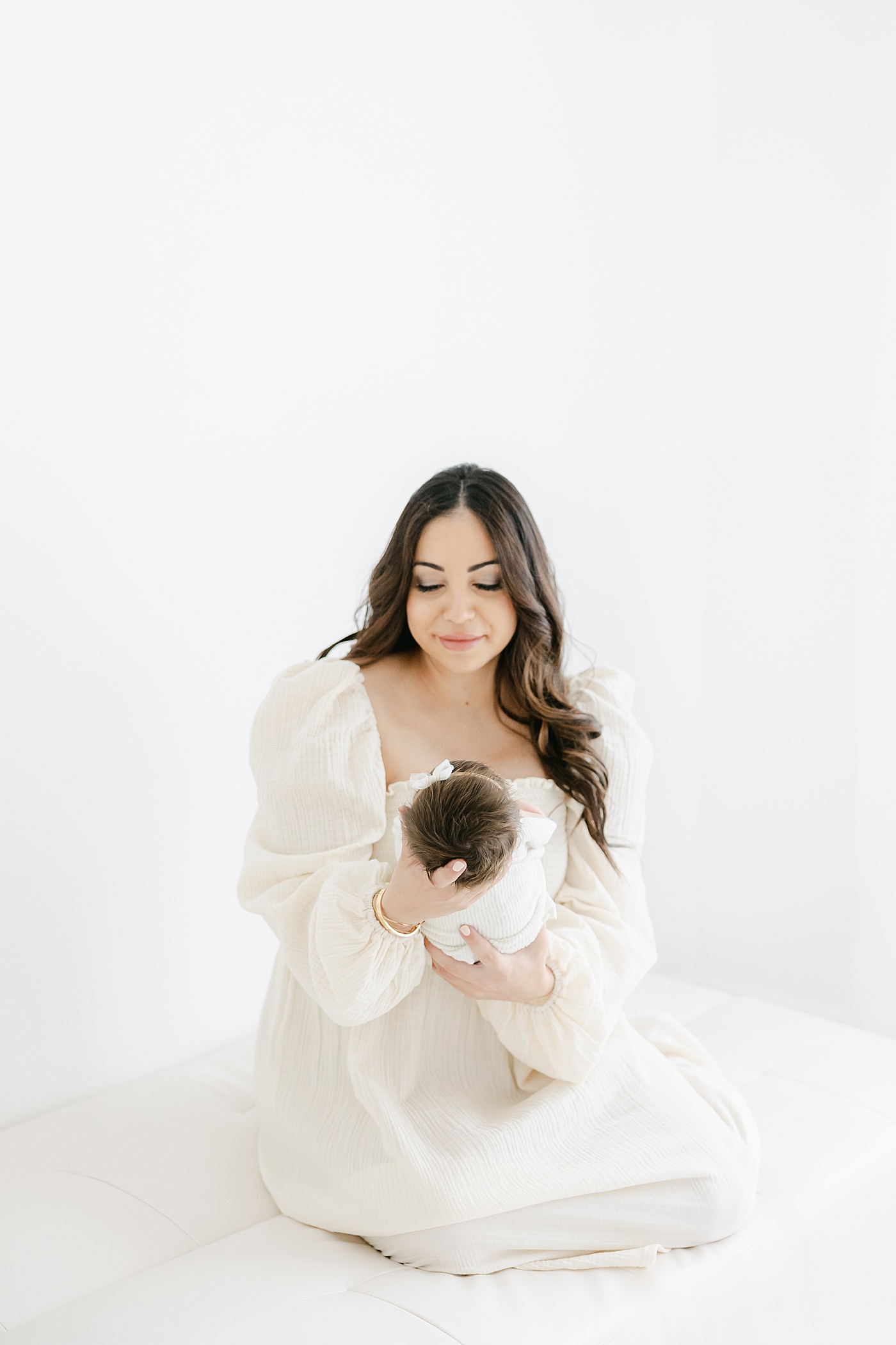 Mom holding newborn daughter wearing a "Nothing Fits But" dress | Kristin Wood Photography