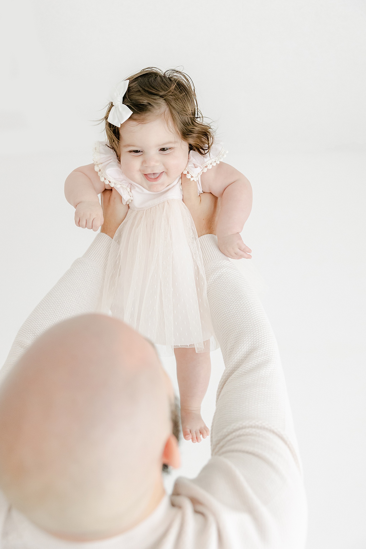 Dad holding daughter up during photoshoot at 6 months | Kristin Wood Photography