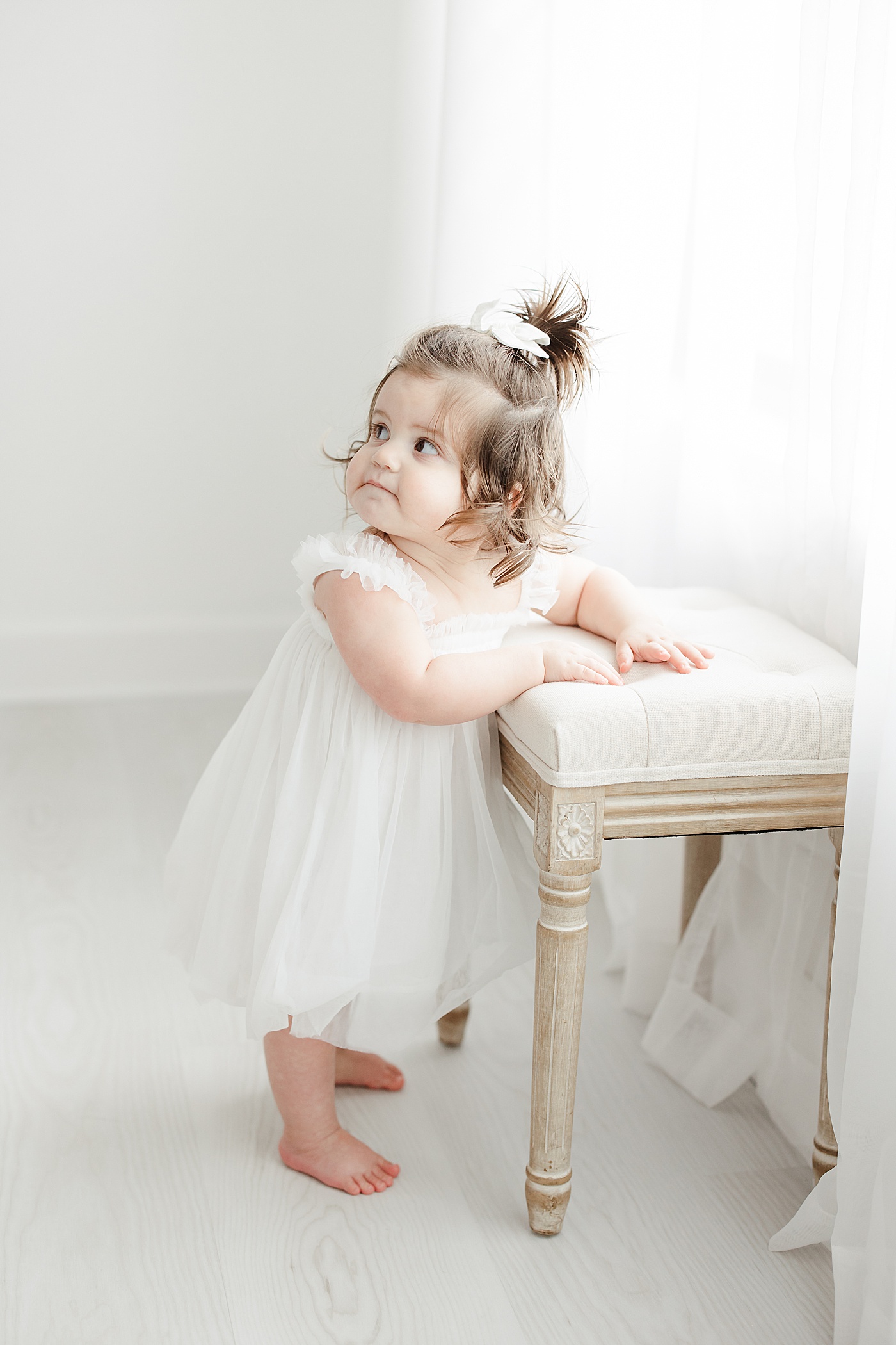 One year old girl standing by stool | Kristin Wood Photography