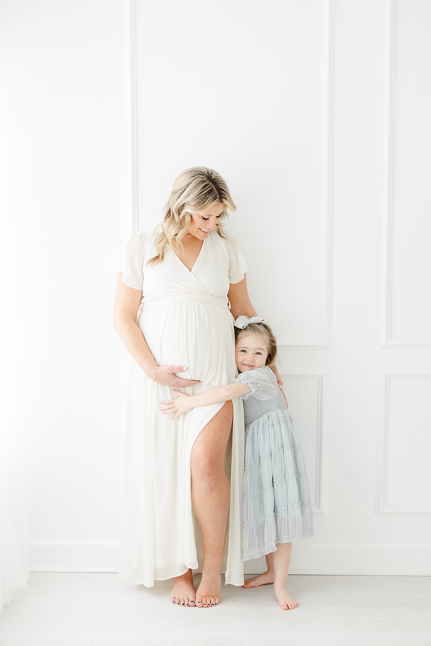 Mom hugging her firstborn daughter during maternity photos with Kristin Wood Photography.